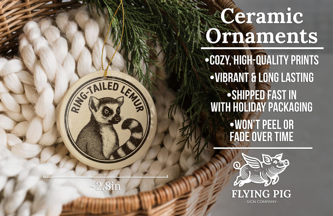 Ceramic ornaments, featuring a ring-tailed lemur, are displayed in a basket with a pine branch.