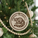 A Christmas tree decorated with ornaments, including a round ornament with a raccoon image and the text "Ringtail Cacomistle".
