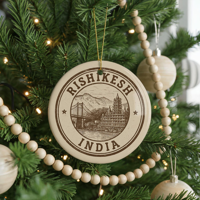 A Christmas tree decorated with ornaments, including a circular ornament with the text "RISHIKESH INDIA" and a drawing of a bridge.