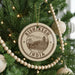 A Christmas tree decorated with ornaments, including a circular ornament with the text "RISHIKESH INDIA" and a drawing of a bridge.