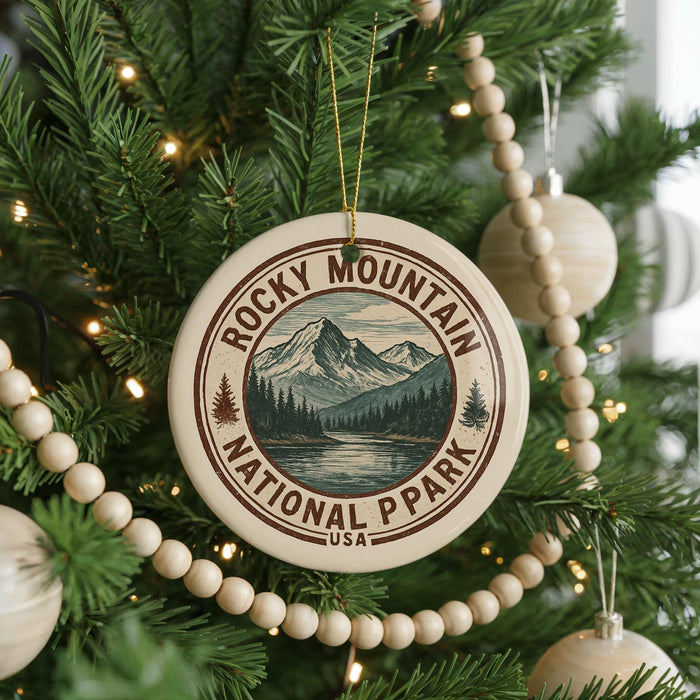 A Christmas tree decorated with ornaments, including a circular ornament with a mountain landscape and text, surrounded by lights and greenery.