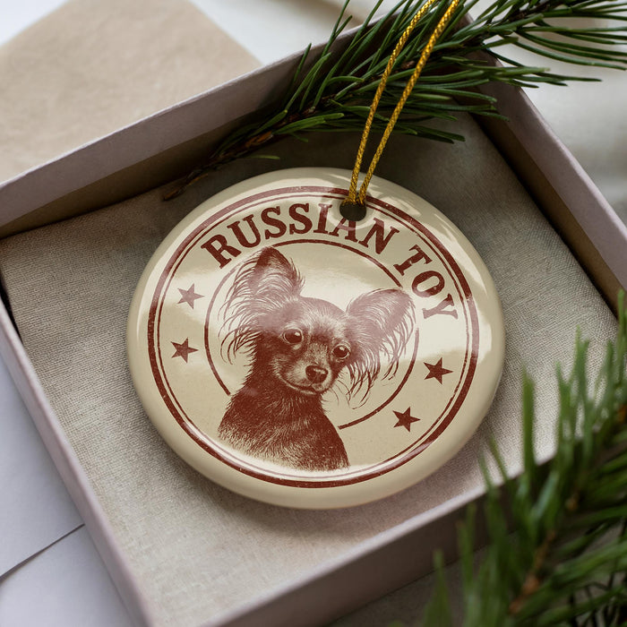 A round ornament with a dog image and the text "RUSSIAN TOY" is displayed in a box, surrounded by pine branches.