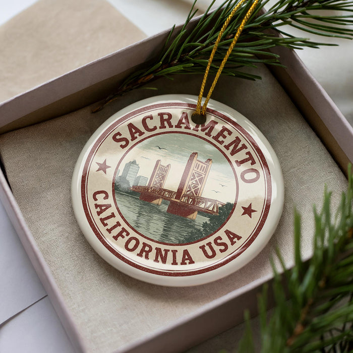 A circular ornament with the text "SACRAMENTO, CALIFORNIA USA" printed on it, surrounded by a border and a graphic of a bridge.