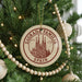 A Christmas tree decorated with ornaments, including a circular ornament with the text "Sagrada Familia" and "Spain" printed on it.