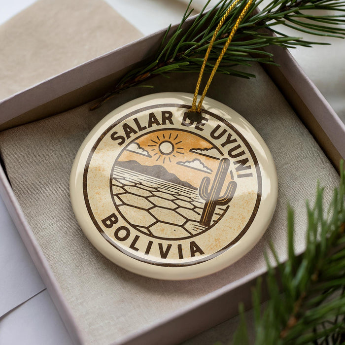 A circular ornament with the text "Salar de Uyuni Bolivia" printed on it, surrounded by a desert landscape and a cactus.