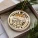 A circular ornament with the text "Salar de Uyuni Bolivia" printed on it, surrounded by a desert landscape and a cactus.