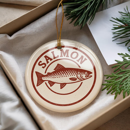A round ornament with a salmon image and the word "SALMON" written on it, hanging from a string.