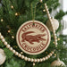 A Christmas tree decorated with ornaments, including a circular ornament with a crocodile design and the text "Saltwater Crocodile" on it.
