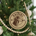 A Christmas tree decorated with ornaments, including a circular ornament with a dog's head and the name "Saluki" written on it.
