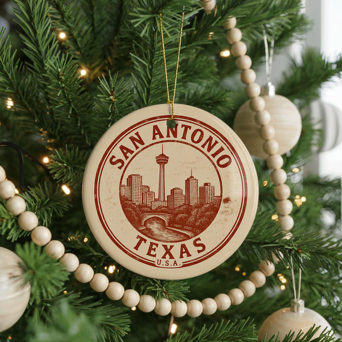 A circular ornament on a Christmas tree, featuring the text "SAN ANTONIO TEXAS U.S.A." and an illustration of the city skyline.