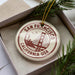 A circular ornament with the text "SAN FRANCISCO CALIFORNIA-USA" printed on it, surrounded by pine branches.