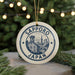 A ceramic ornament with the text "SAPPORO JAPAN" and an illustration of Sapporo, a city in Japan, is displayed on a Christmas tree.