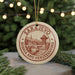 A circular ornament with the text "SARajevo, Bosnia and Herzegovina" and an illustration of a cityscape is hanging from a string.