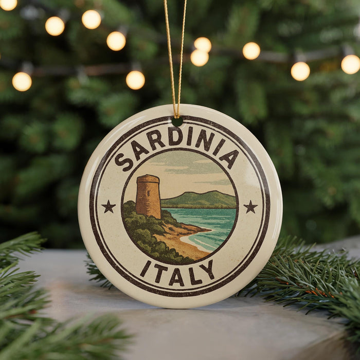 A circular ornament with the text "SARDINIA ITALY" and an illustration of a tower overlooking a beach, surrounded by Christmas lights.
