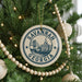 A circular ornament on a Christmas tree, featuring the text "SAVANNAH GEORGIA" and an illustration of the Atlanta skyline.