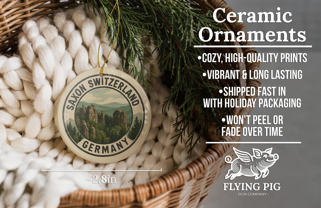 Ceramic ornaments, specifically a saxon switzerland Germany ornament, are displayed in a woven basket. The ornament features a scenic image of the Saxon Switzerland mountains. The image is accompanied by text highlighting the ornament's features, such as its cozy, high-quality prints, vibrant and long-lasting vibrancy, and fast shipping. The text also mentions that the ornament won't peel or fade over time.