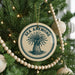 A Christmas tree decorated with ornaments, including a circular ornament with the text "SEA ANEMONE" and a beaded ornament.