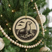 A Christmas tree decorated with ornaments, including a circular ornament featuring a seal.