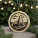 A round ornament featuring a seal sitting on a rock, with a background of a blurred Christmas tree.