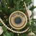 A Christmas tree decorated with ornaments, including a circular ornament with a design resembling a sea urchin and the text "SEA URCIN" on it.
