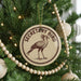 A round ornament on a Christmas tree, featuring a bird design and the text "SECRETARY BIRD".