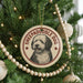 A circular ornament on a Christmas tree featuring a sheepdog, with the text "SHEPADOOLE DOG" around the edge.