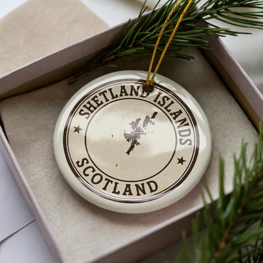 A circular ornament with the text "SHETLAND ISLANDS SCOTLAND" printed on it, surrounded by pine branches.