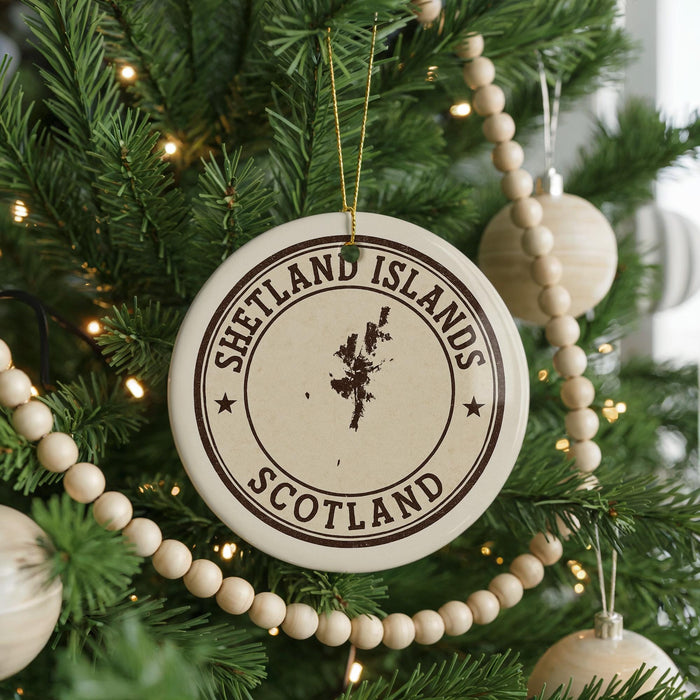 A Christmas tree decorated with ornaments, including a circular ornament with the text "SHETLAND ISLANDS SCOTLAND" printed on it.