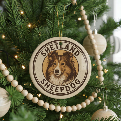 A Christmas tree decorated with a circular ornament featuring a Shetland Sheepdog image, surrounded by beaded ornaments and twinkling lights.