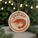 A circular ornament with the word "SHRIMP" in red text, featuring a red shrimp illustration, is hanging from a string.