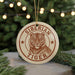 A circular ornament with the text "SIBERIAN TIGER" and a tiger illustration is displayed in front of a Christmas tree with twinkling lights.