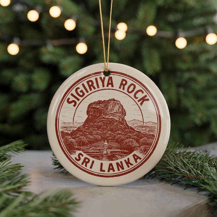 A circular ornament with the text "SIGIRIYA ROCK" and "SRI LANKA" printed on it, hanging from a string.