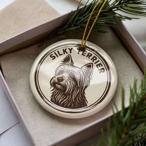 A ceramic ornament in a box, featuring a close-up image of a Silky Terrier dog.