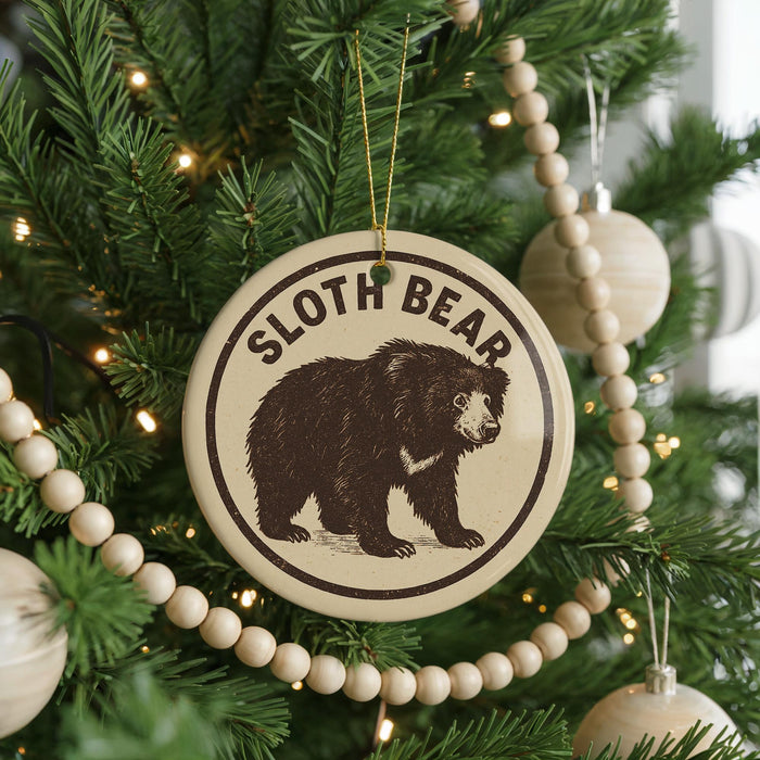 A Christmas tree decorated with ornaments, including a circular ornament with a sloth bear image and the text "SLOTH BEAR" on it.