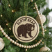 A Christmas tree decorated with ornaments, including a circular ornament with a sloth bear image and the text "SLOTH BEAR" on it.