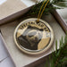 A decorative ornament featuring a close-up image of a bear's face, with the text "SPECTACED BEAR" around the image.