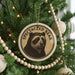 A Christmas tree decorated with ornaments, including a circular ornament with a bear image and the text "SPECTACLEED BEAR".