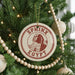 A Christmas tree decorated with ornaments, including a circular ornament with the text "SPHINX EGYPT" and a wooden bead decoration.