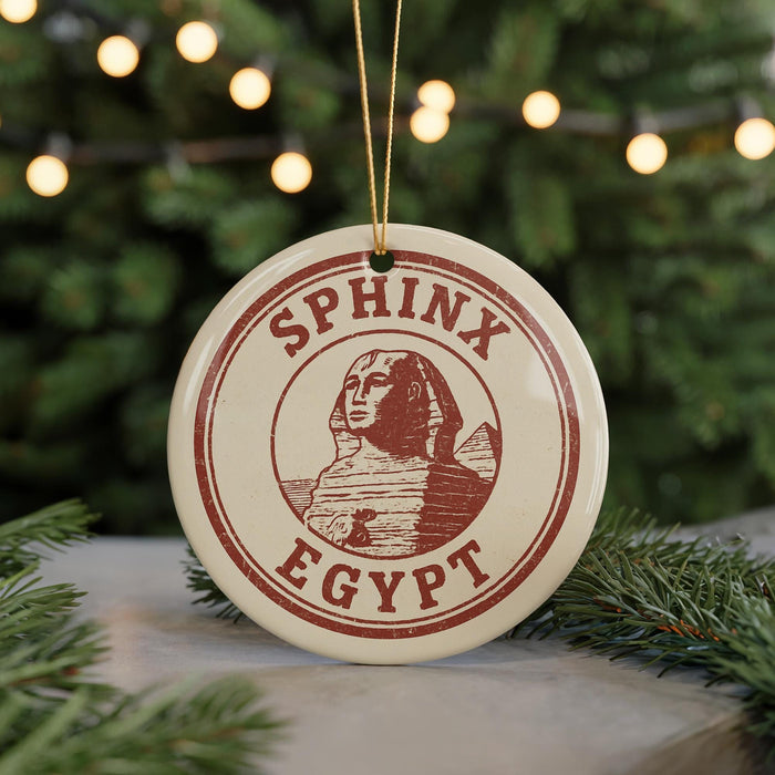 A round ornament with the text "SPHINX EGYPT" and an illustration of the Sphinx is displayed on a Christmas tree.