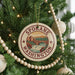 A round ornament on a Christmas tree, featuring the text "SPOKANE WASHINGTON" and an illustration of a bridge and waterfall.