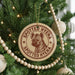 A Christmas tree decorated with ornaments, including a circular ornament with a hyena image and the text "SPOTTED HYENA SPOTTED HYENA" printed on it.