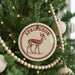 A Christmas tree decorated with ornaments, including a circular ornament with a deer image and the word "Springbok" written on it.