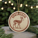 A round ornament with a deer image and the word "SPRINGBOK" printed on it, hanging from a string.