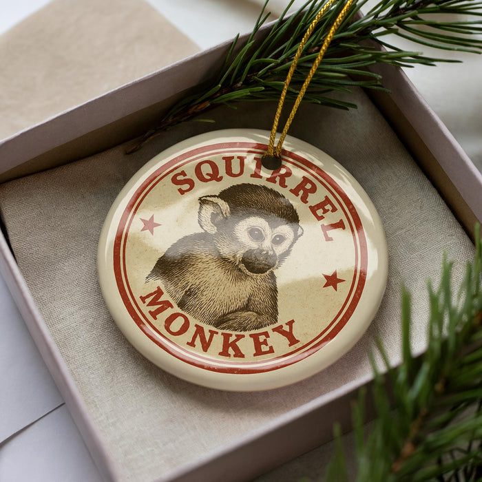 A round ornament with a monkey image and the text "SQUIRREL MONKEY" is displayed in a box, surrounded by pine branches.
