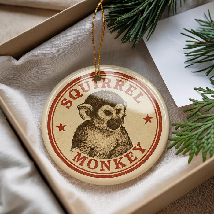 A round ornament with a monkey image and the text "SQUIRREL MONKEY" is displayed in a box with pine branches.