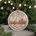 A circular ornament with a red and white design featuring the St. Louis, Missouri skyline and the text "St. Louis Missouri - USA" is displayed on a Christmas tree.