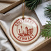 A circular ornament with the text "STUTTGART GERMANY" printed on it, hanging from a string.