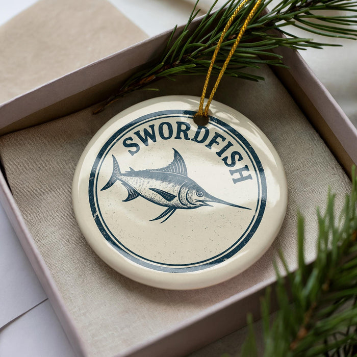 A decorative ornament in a box, featuring a blue and white design of a swordfish.
