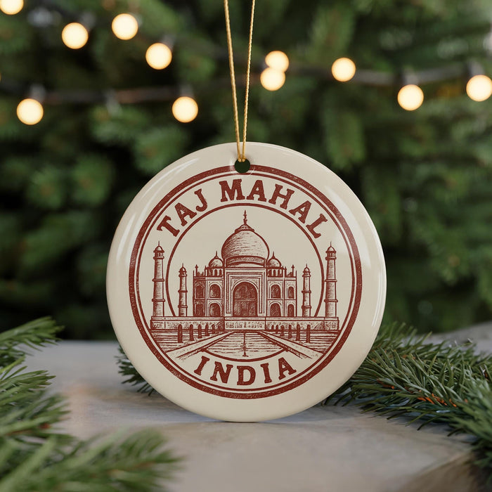 A circular ornament with the text "Taj Mahal India" and an illustration of the Taj Mahal, a famous mausoleum in India, is displayed in front of a Christmas tree with twinkling lights.