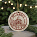 A circular ornament with the text "Taj Mahal India" and an illustration of the Taj Mahal, a famous mausoleum in India, is displayed in front of a Christmas tree with twinkling lights.